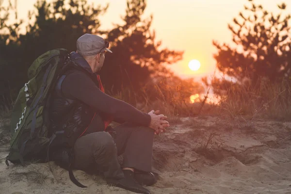 Turist med ryggsäck titta på vacker solnedgång — Stockfoto