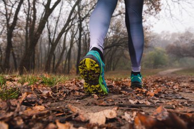 Kadın spor ayakkabılarını toprakla kapatıyorlar.