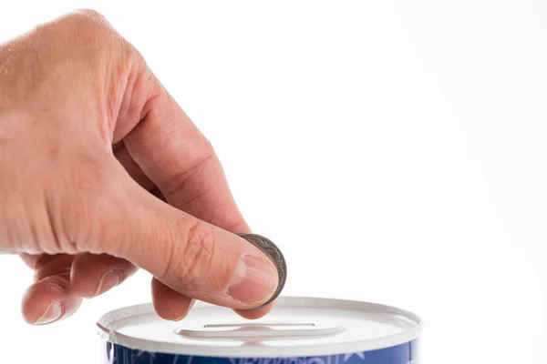 Male hand putting a coin into tin can saving bank — Stock Photo, Image