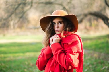 Geniş şapkalı ve kırmızı ceketli esmer.