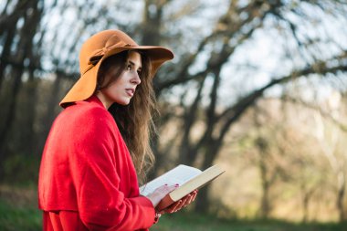 Sonbahar parkında bankta oturan bir kızın arka görünüşü