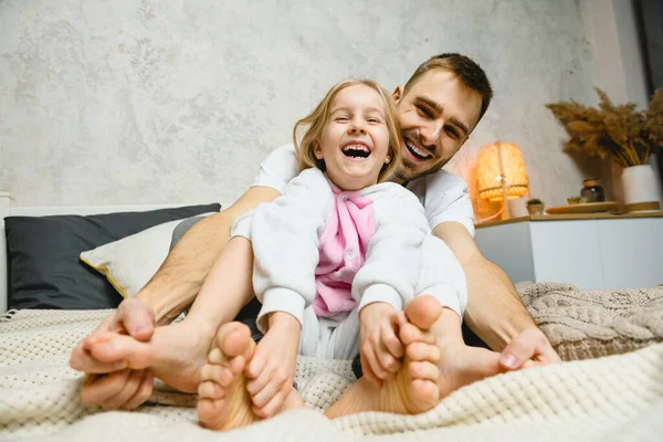 Pijamalı Gülümseyen Bir Baba Kız Baba Kızı Birbirlerinin Ayaklarını Gıdıklıyor — Stok fotoğraf