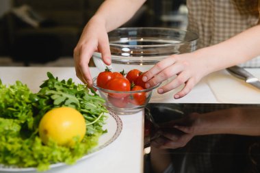 Masada salata malzemesi olan kadın elleri.