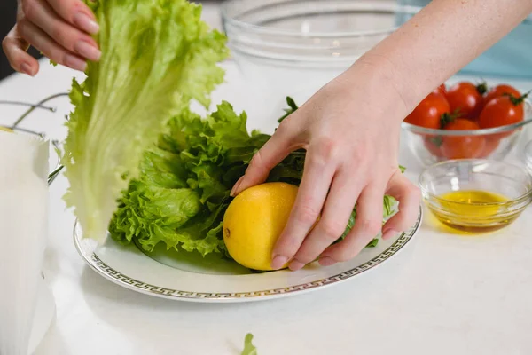レモンとサラダの葉を持つ女性の手 — ストック写真