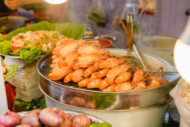 Asya Tayland sokak deniz ürünleri tezgahı, şempanzelerle dolu. Sıcak turuncu renkler, yüksek protein kesesi..