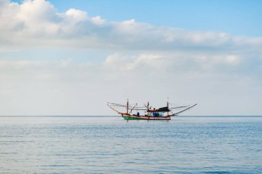 Deniz yüzeyinde geleneksel balıkçı teknesiyle güzel bir manzara, Tayland