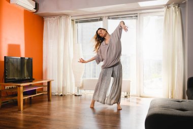 Karantina zamanında evde dans eden bir kadın.