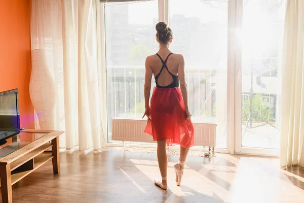 Ballet dancer stay back to window indoors