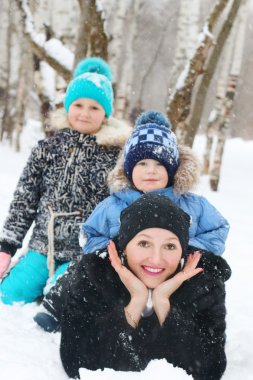 İki çocuk mutlu anne kar kar yağışı sırasında yatıyor. 