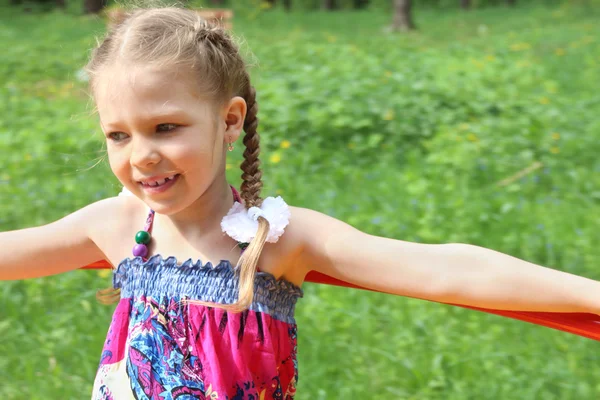 Happy little cute girl rides on roundabout in sunny park at summ — Stock Photo, Image