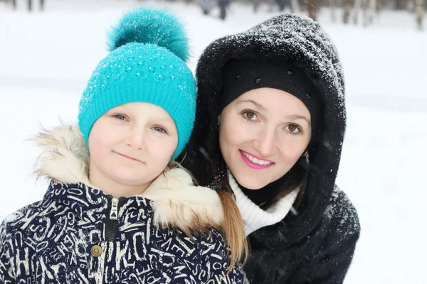 Счастливая мать с дочерью обнимаются в зимний день — стоковое фото