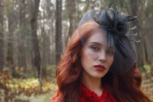 Pretty girl in black retro hat poses in autumn forest — Stock Photo, Image