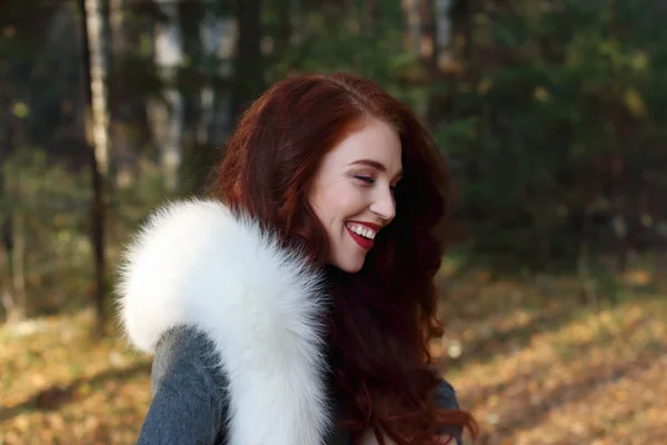 Hübsches Mädchen mit Make-up und weißem Fell lacht im Wald — Stockfoto