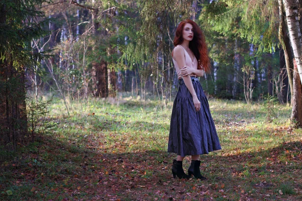 Sexy woman in skirt and belt poses on wind in autumn forest — Stock Photo, Image