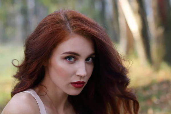 Menina bonita com cabelo encaracolado vermelho posa na floresta, dof rasa — Fotografia de Stock