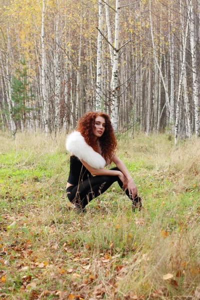 Belle femme avec des poses de fourrure blanche dans la belle forêt d'automne — Photo