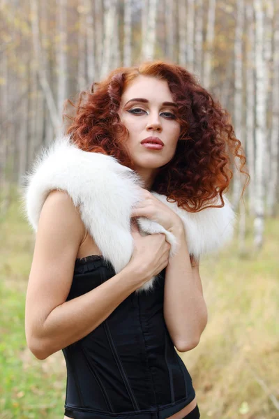 Güzel kadını korse beyaz kürk ile sonbahar ormanda teşkil etmektedir. — Stok fotoğraf