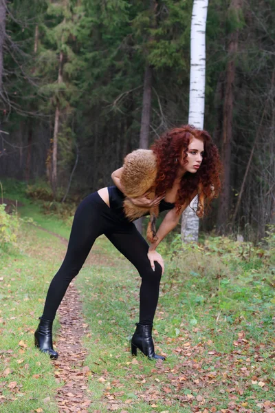 Красива молода жінка в корсеті з хутряною позою в осінньому лісі — стокове фото