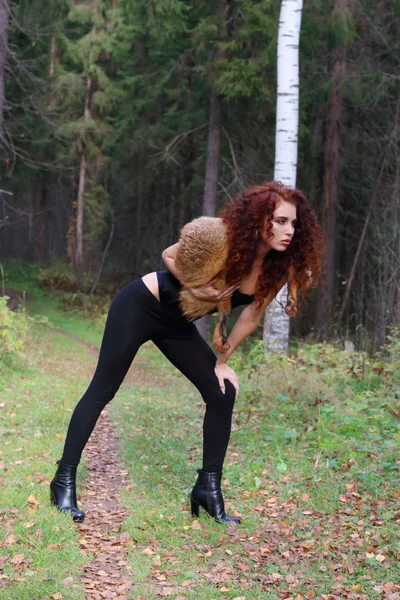 Pretty young woman in corset with fur pose in autumn forest — Stock Photo, Image