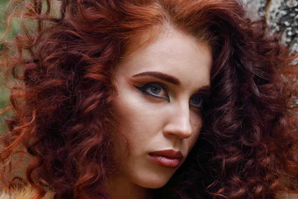 Лицо красивой женщины с макияжем и вьющиеся волосы на открытом воздухе — стоковое фото