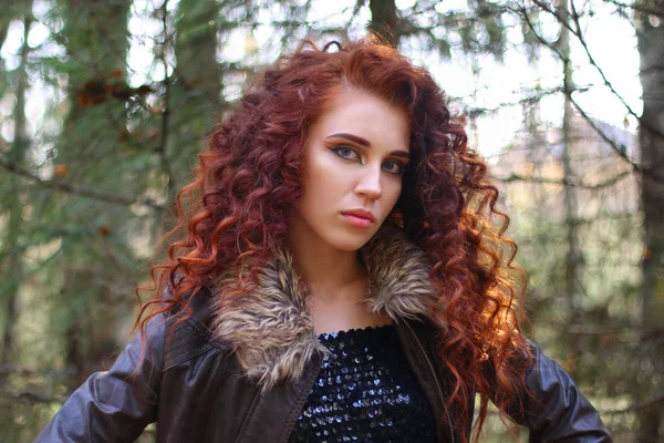 Beautiful woman with curly hair in leather jacket in sunny autum — Stock Photo, Image