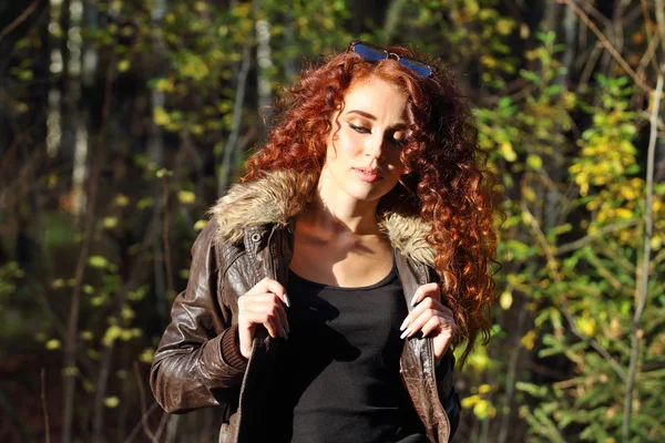 Mujer bonita con gafas de sol posa en un día soleado en el bosque de otoño —  Fotos de Stock