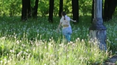 Küçük güzel kızın ağaçları yaz Park arasında çalışır