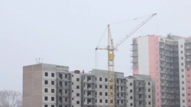 Kış günü kar yağışı sırasında inşaatta vinç çalışma