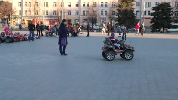 Perm, Oroszország - 2016. április 26.: A fiú autó lovagol téren Dráma Színház közelében — Stock videók