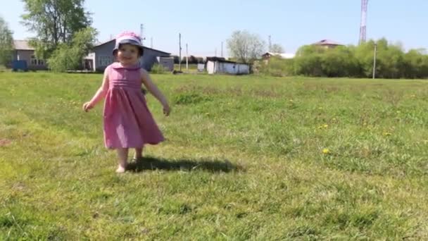 Felice bambina va su erba verde in soleggiata giornata estiva — Video Stock