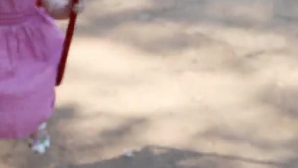 Little happy girl in hat swings on children playground at spring day, close up — Stock Video