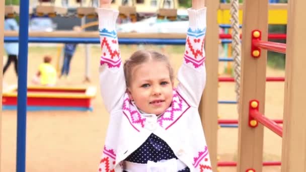 Menina bonita joga no parque infantil no dia de verão — Vídeo de Stock