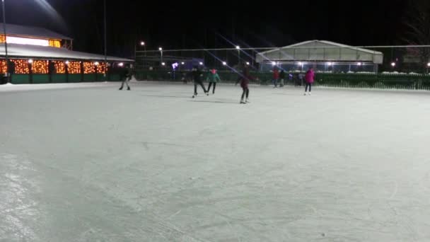 Tanınmayan insanlar paten buz pateni kış geceleri üzerinde — Stok video