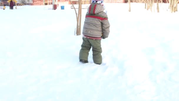幸せな小さな男の子は、冬の晴れた日でシャベルの雪を掘り — ストック動画