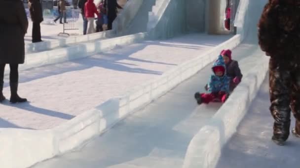 Perm, Rusland - 14 februari 2016: Kinderen op ijs dia, Ice stad in Perm - traditionele winter attractie — Stockvideo