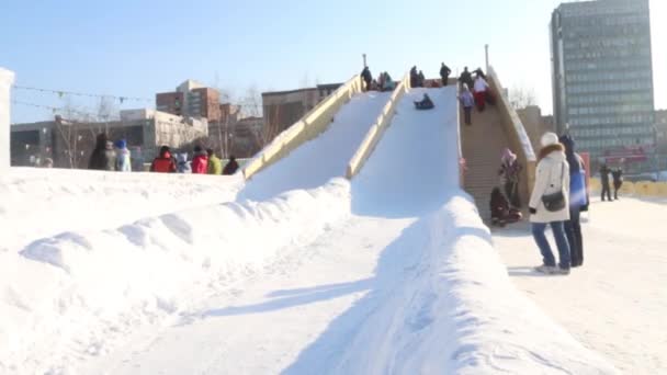 Dauerwelle, Russland - 14. Februar 2016: Snowtubing in der Eisstadt, Eisstadt in Dauerwelle - traditionelle Winterattraktion — Stockvideo