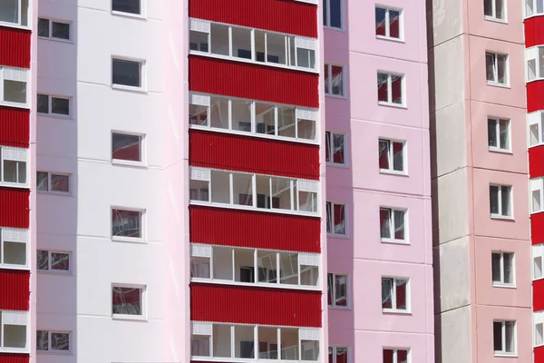 Teil eines neuen rosafarbenen Wohnhauses mit roten Balkonen und — Stockfoto