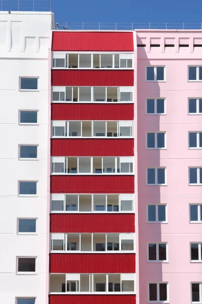 Deel van roze residentieel gebouw met rode balkons op zonnige da — Stockfoto