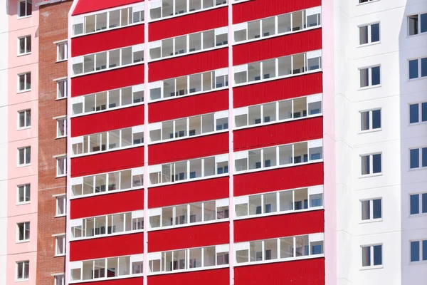 En del av nya rosa bostadshus med röda balkonger på sun — Stockfoto