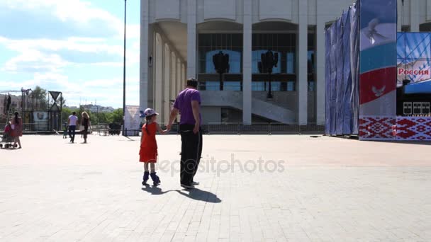 Padre juega con su hija (con lanzamientos de modelos) en patines en la plaza central — Vídeo de stock