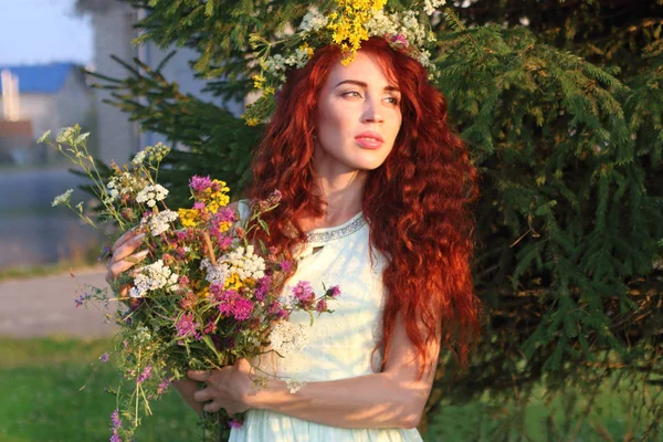 Mujer en corona con ramo de flores cerca de abeto en verano da — Foto de Stock