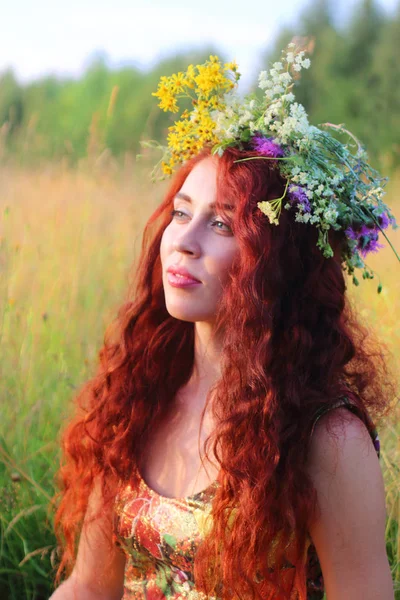 Bella donna in ghirlanda con i capelli rossi in campo secco in estate d — Foto Stock