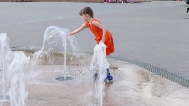 Flicka på rullskridskor leker med torr fontän i sommarstaden, Slowmotion — Stockvideo