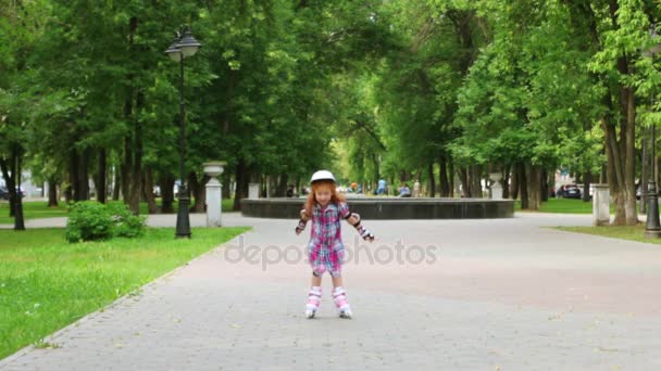 Schattig klein meisje in de helm rolschaatsen in groene zomer park — Stockvideo