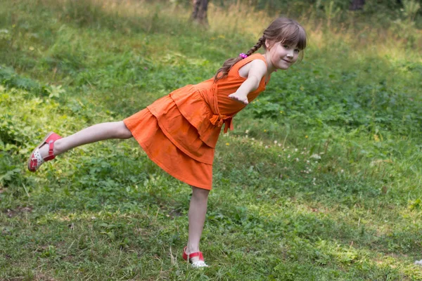 Szczęśliwy całkiem mała dziewczynka przedstawia ptaka na trawie w lesie słoneczny — Zdjęcie stockowe