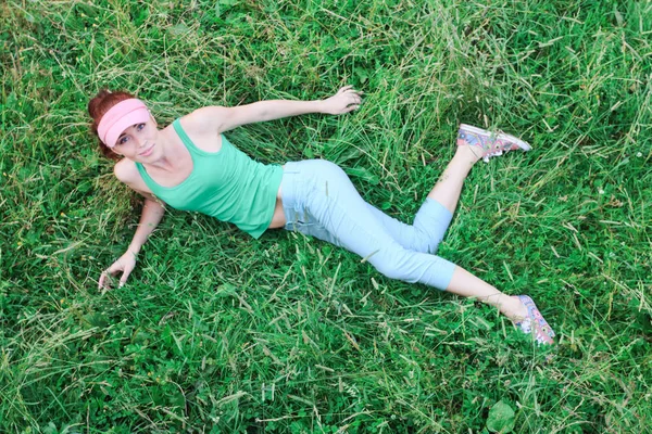 Cute young girl in green t shirt and blue shorts and a pink viso — Stock Photo, Image