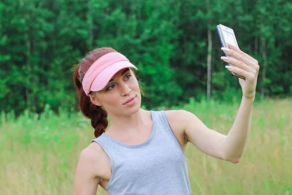 自然の背景に、selfie を取っているかなり若い女の子、 — ストック写真