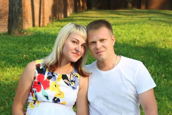 Happy blonde woman and young man pose together in summer green p Stock Photo