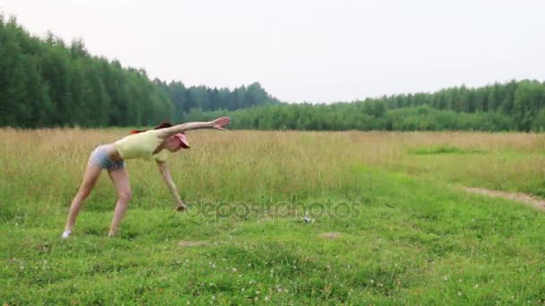 Mooi meisje oefent Salto op weide op zomeravond — Stockvideo