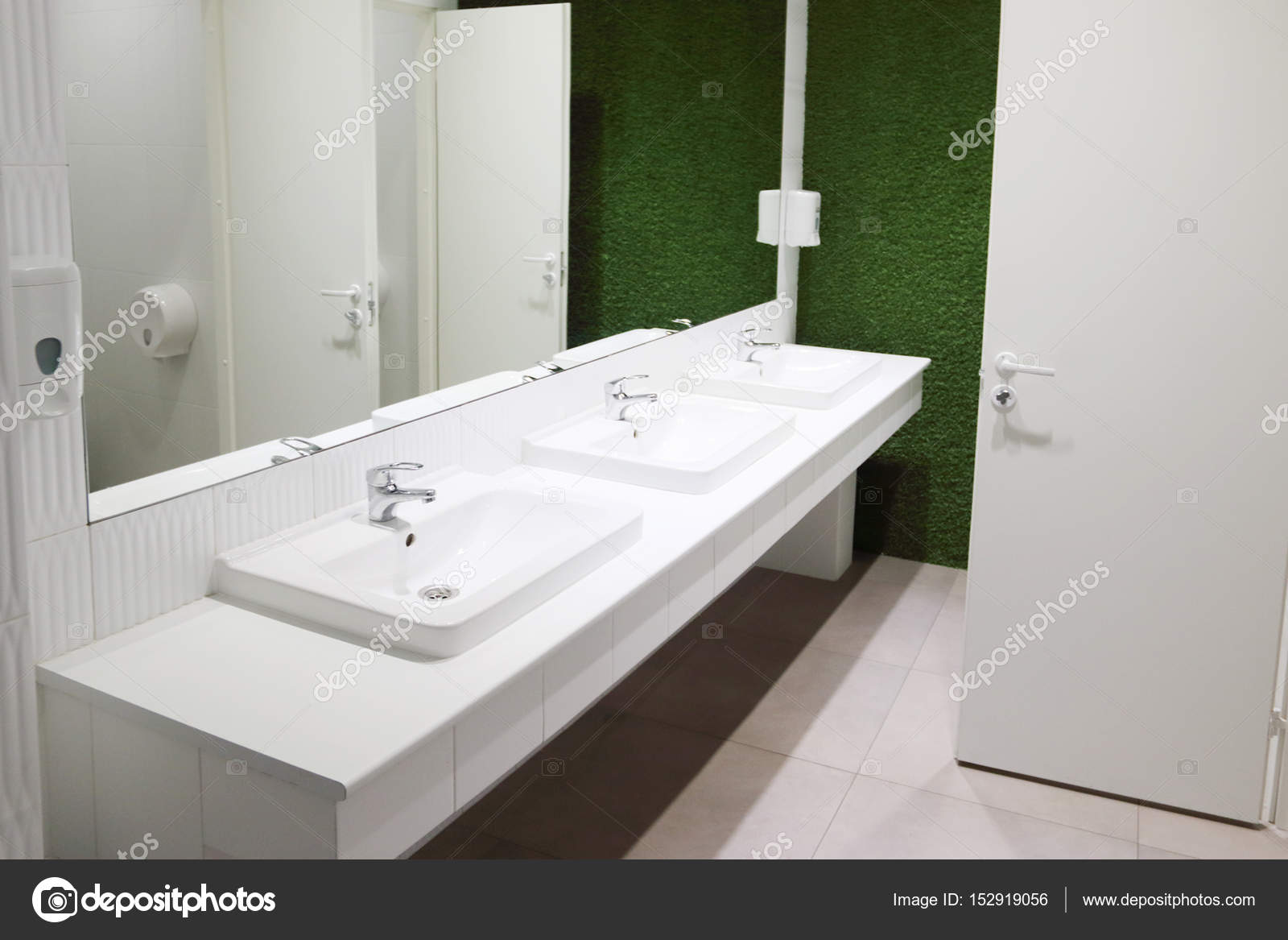 Bianchi tre lavandini in bagno con grande specchio e parete verde ... Bianchi tre lavandini in bagno con grande specchio e parete verde ...